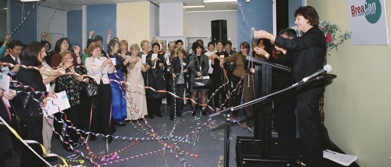 A crowd celebrate and release party poppers as Minister for Health, the Hon. Bronwyn Pike, launches BreaCan in 2003.