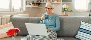 woman on couch with laptop and cup of tea
