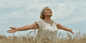 woman standing in field with open arms