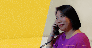 A Peer Support Volunteer on the phone. Yellow and white design elements overlay the photo.