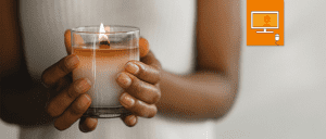hands holding a candle in front of body