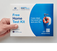 Hand holding a cardboard box with Free Home Test Kit printed on the front.