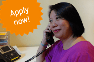 Volunteer on the phone, starburst superimposed with the words Apply Now