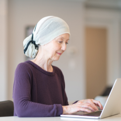 Woman wearing head scarf on laptop at home