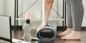 Laptop computer with yoga mat and feet of yoga participant