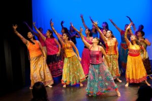 a group of women performing bollywood dance on stage